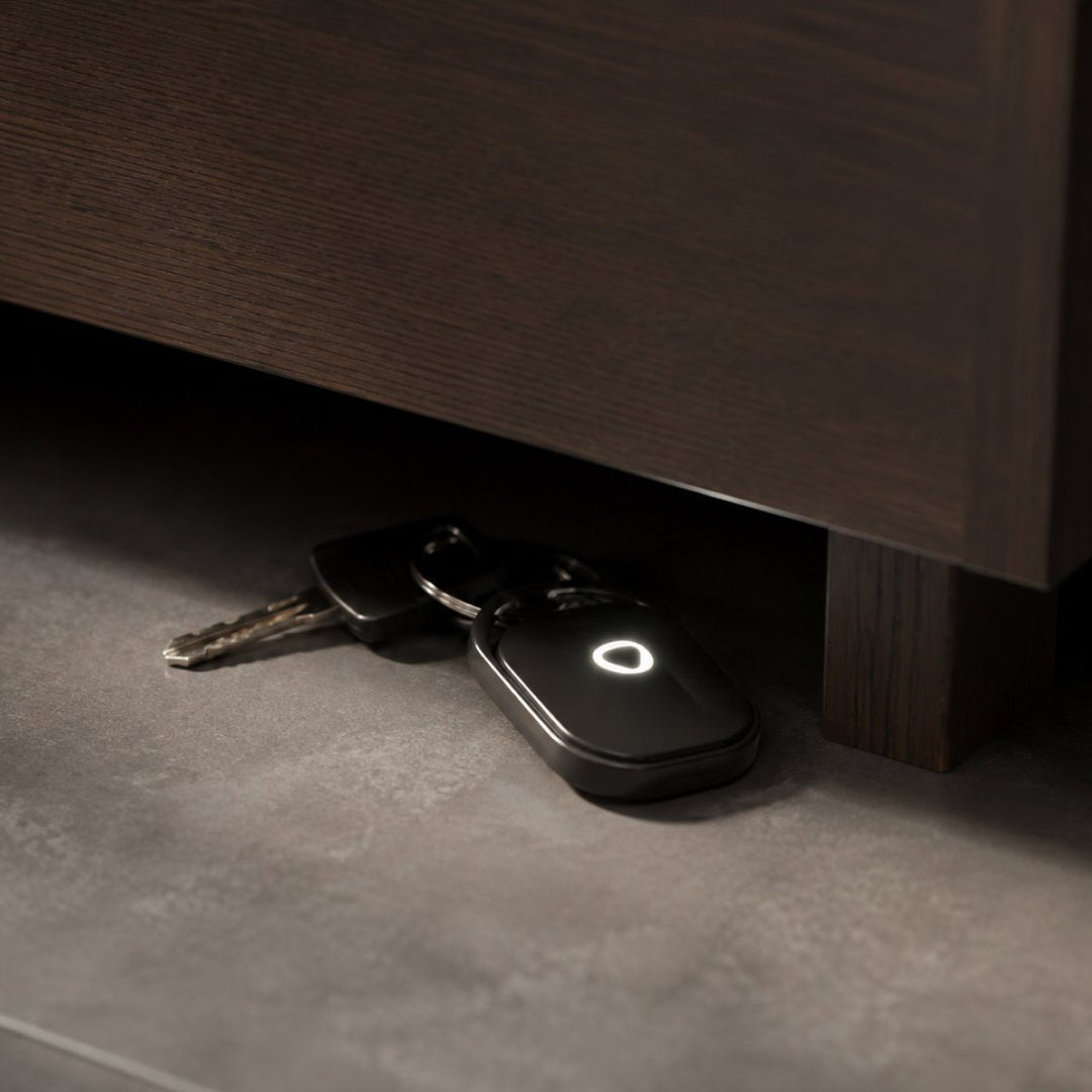 Smart Tag LED glowing on a set of keys under a cabinet