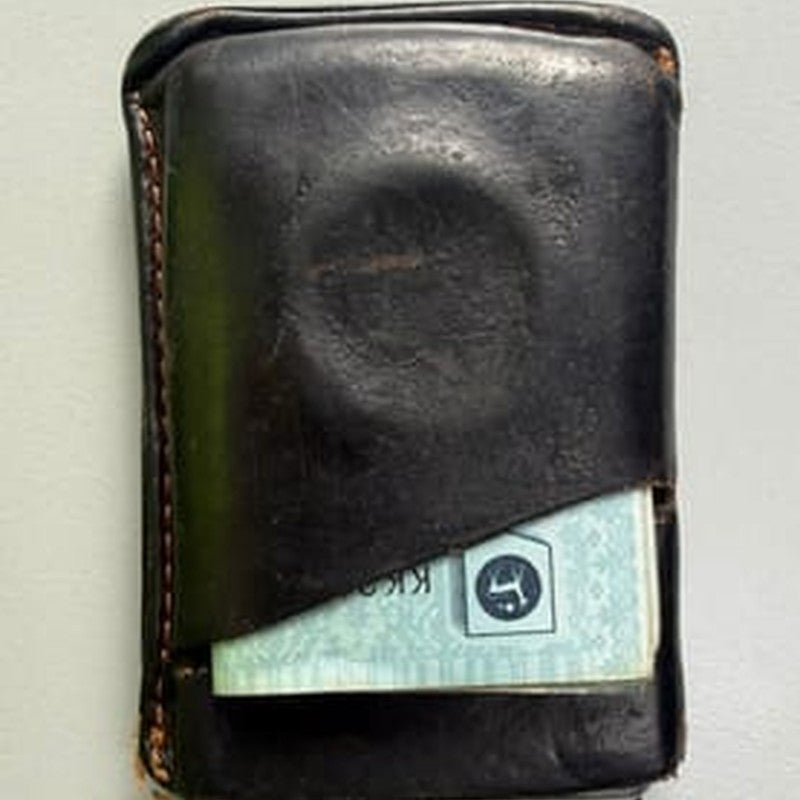 A wallet with the dent an AirTag left in it