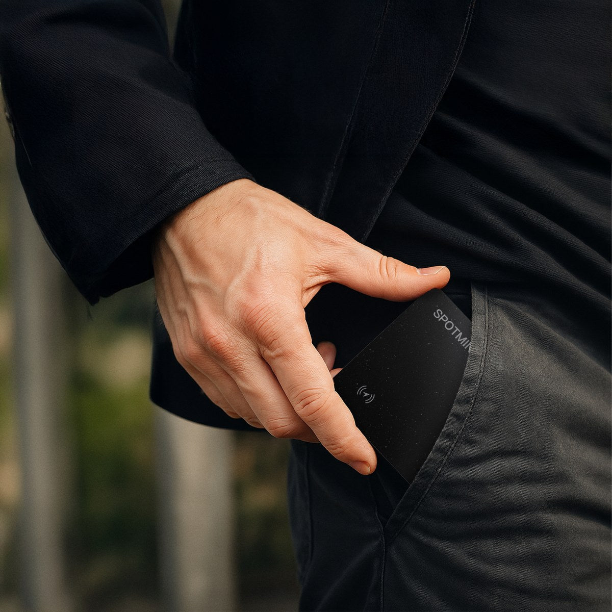 A man slipping the Spotminders card into his jacket pocket