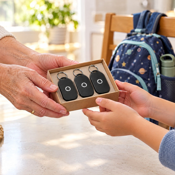 A grandmother handing a child a gift box with three Spotminders Smart Tags, a school backpack on the chair behind